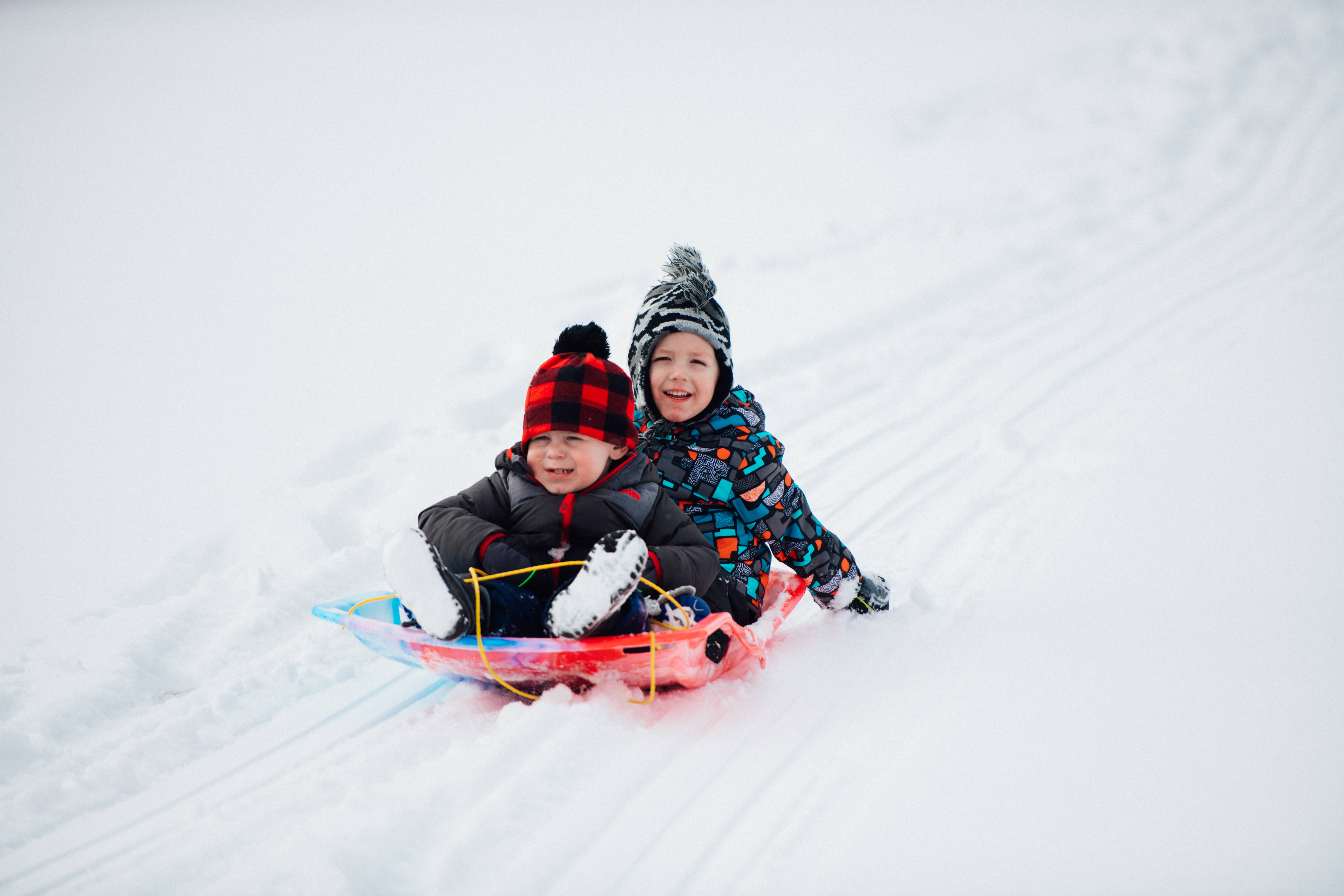 Two children sledding in Waterford MI