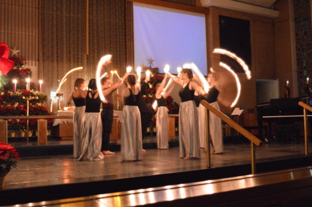 Eight dancers holding up candles during the Christmas Eve dance performance at Central United Methodist Church in Waterford MI