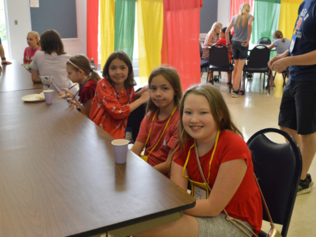 Four girls in red shirts sitting at a table at Central UMC's vacation bible school in Waterford MI