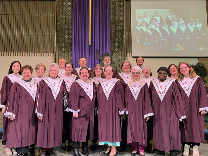 A group of people in plum-colored choir robes that are members of the Chancel Choir of Central UMC in Waterford, MI