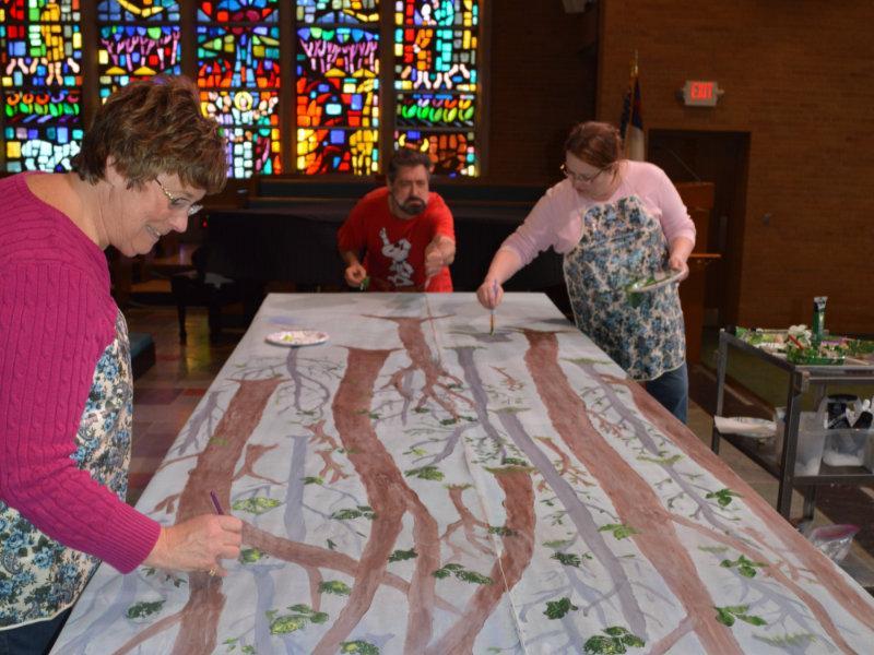 Three people painting a backdrop used for a Message Series at Waterford Central UMC in Michigan